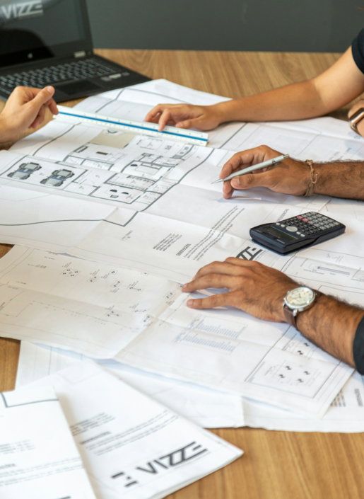 people reviewing architectural blueprints on desk